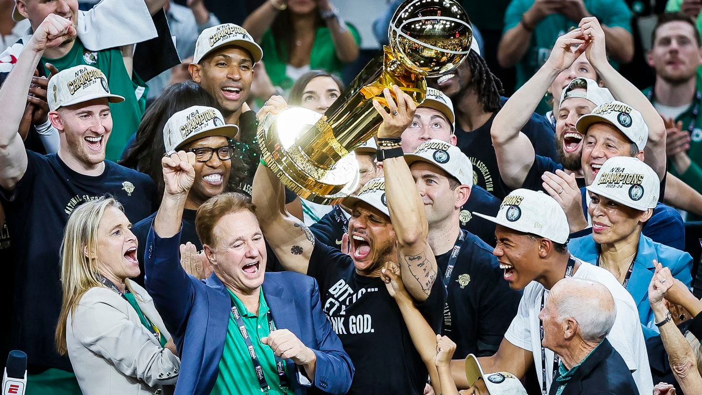 Head coach Joe Mazzulla hoists the Larry O'Brien trophy on Monday night.