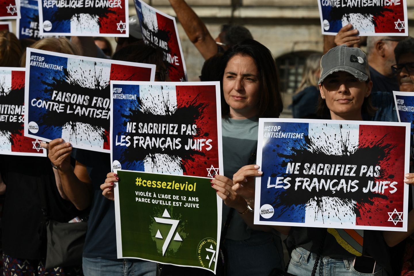 Protesters hold placards which read "Do not sacrifice French jews" as they gather to condemn the alleged anti-semetic gang rape of a 12 year-old girl, during a rally on Lyon Terreaux square in Lyon, central eastern France, on June 19.