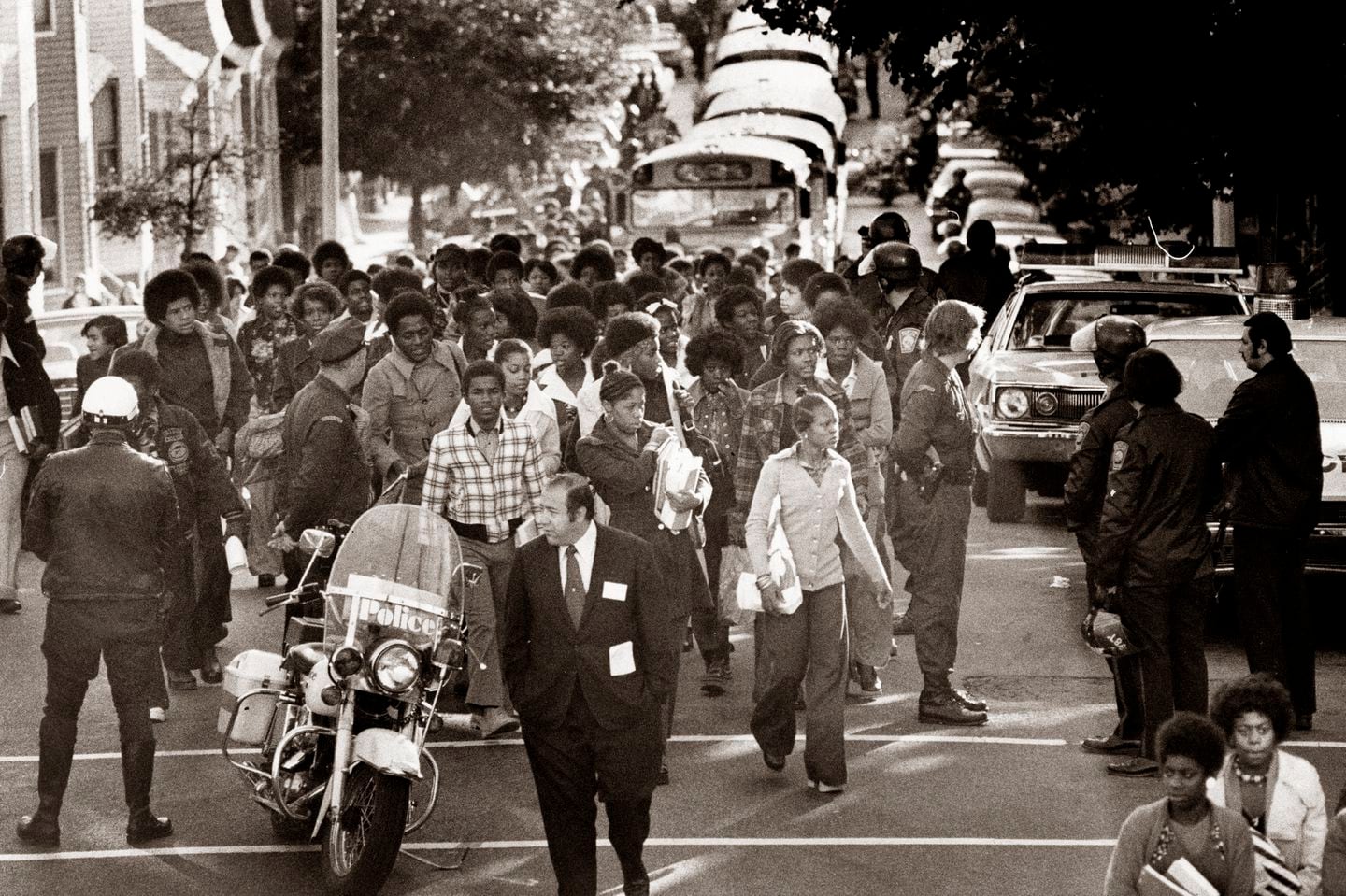 Students had to walk the last 100 yards to South Boston High School after the first school bus in line ran out of gas on Sixth Street on Oct. 1, 1974. (Ulrike Welsch/Globe Staff)