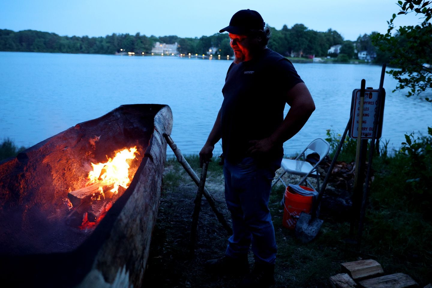 The fire from the inside of a dugout canoe, referred to by Indigenous people as a mishoon, lit the face of George Bearclaw as he took the night shift to keep an eye on the flames and continue to scrape and shape the mishoon in Shrewsbury. For the first time since the 1640s, a mishoon was created near Lake Quinsigamond by members of the Hassanamisco band of the Nipmuc Tribe.